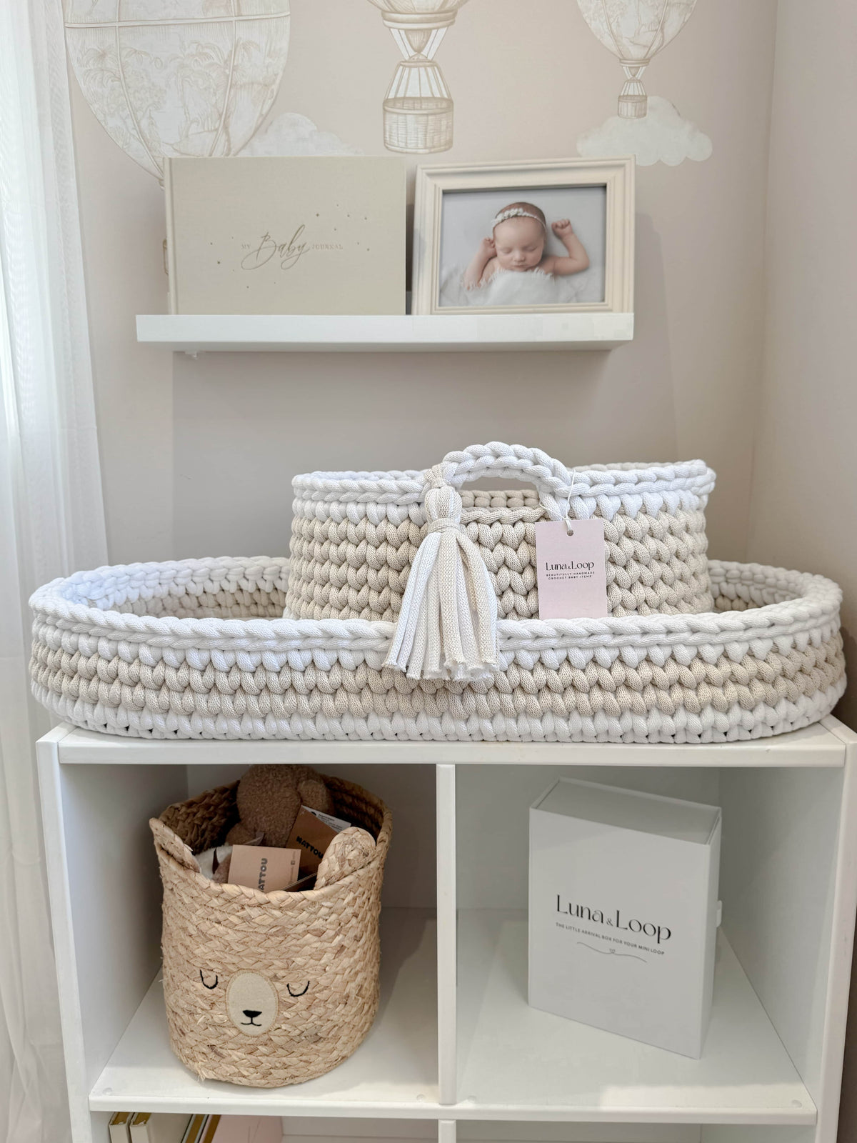 Beige and white crochet changing basket with nappy caddy on a nursery shelf