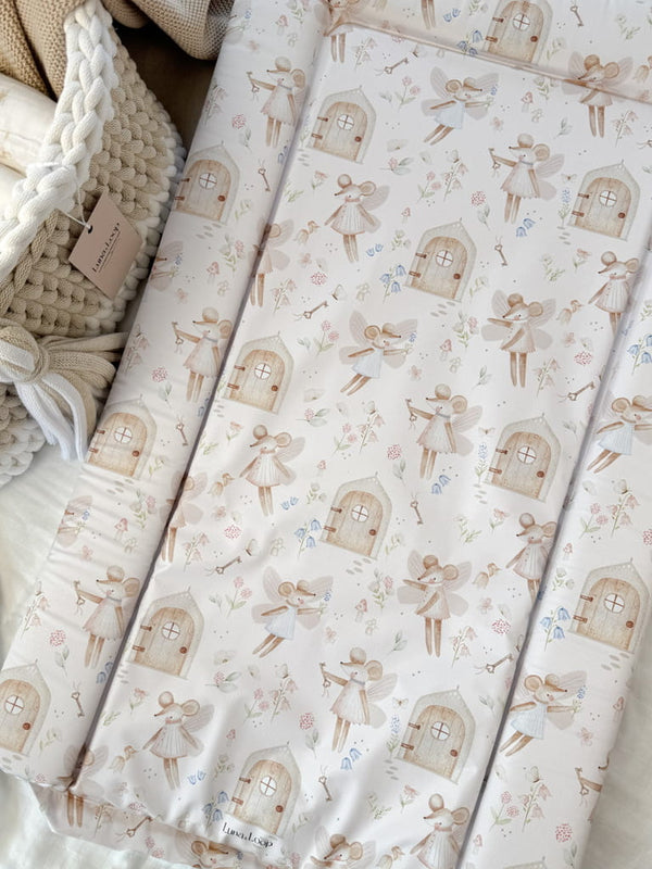 Baby changing mat in sweet fairy print beside a crochet basket